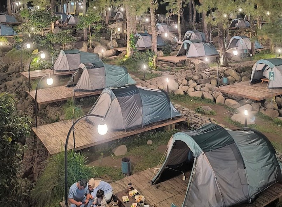 Area glamping di tengah hutan pinus saat malam hari di Jolotundo Glamping and Edupark!