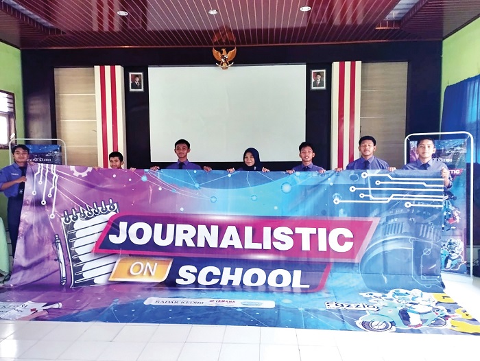 Pelajar SMAN 1 Ngronggot mengangkat banner kegiatan pendidikan dan pelatihan jurnalistik di ruang aula sekolahnya kemarin.