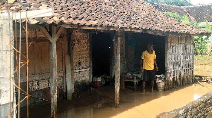 Warga Lingkungan Santren, Kelurahan Kapas mengurasi rumahnya karena banjir.