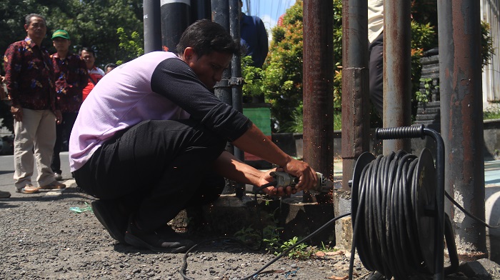Petugas DPMPTSP dan Satpol PP memotong tiang wifi ilegal di Ganungkidul, Nganjuk.
