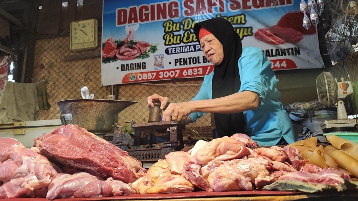 Darinem menimbang daging di Pasar Wage Nganjuk kemarin. Harga daging sapi meembus angka Rp120 ribu per kilogram