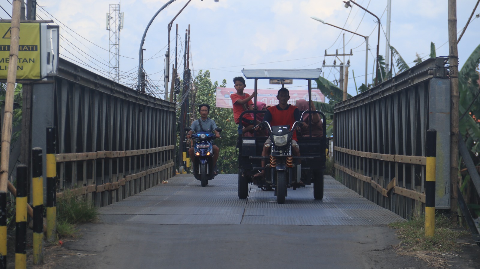 BERBAHAYA: Pengendara sepeda motor dan kendaraan roda tiga melintas di Jembatan Bailey Kutorejo kemarin. Jembatan sementara tersebut akan dibongkar bulan ini oleh Pemerintah Provinsi Jawa Timur.