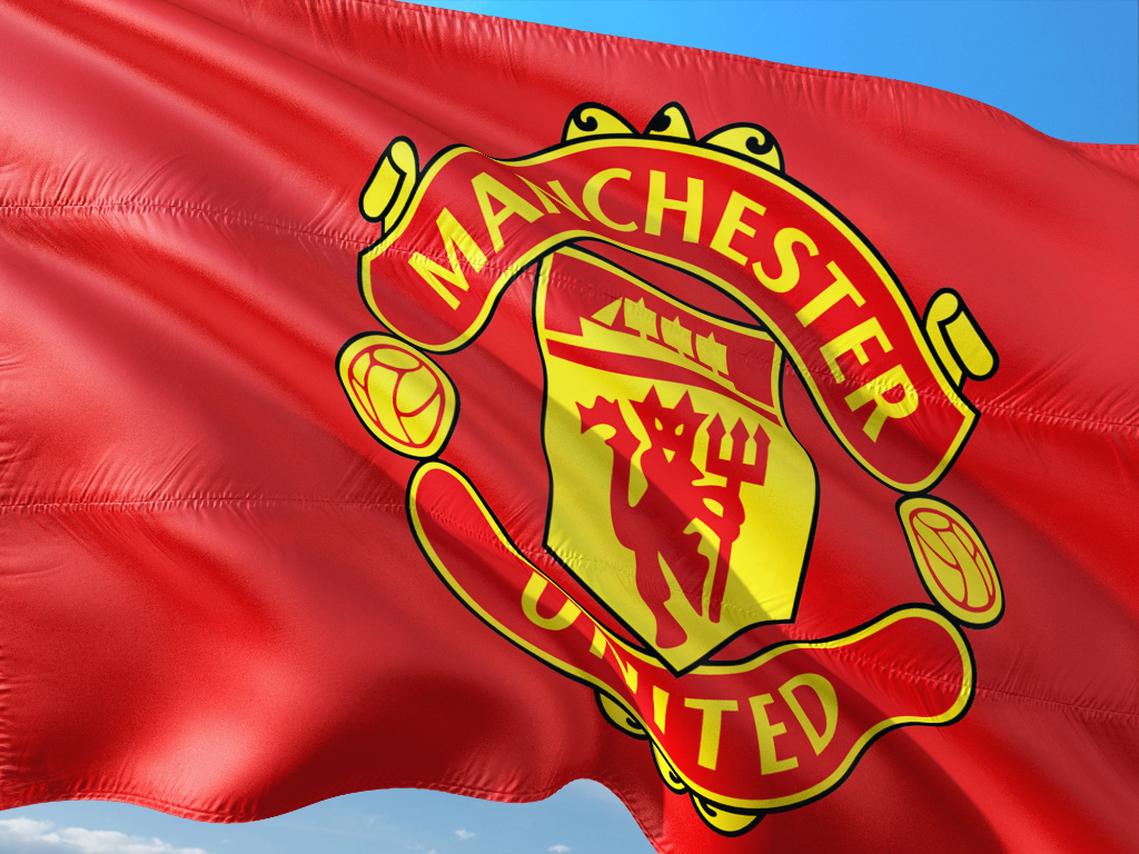 close-up photo of red and yellow Manchester United flag