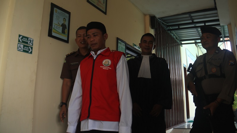 LEMAS:  Sutrisno digelandang menuju ruang tahanan di Pengadilan Negeri Nganjuk setelah sidang kemarin. Sutrisno dituntut 18 tahun penjara.