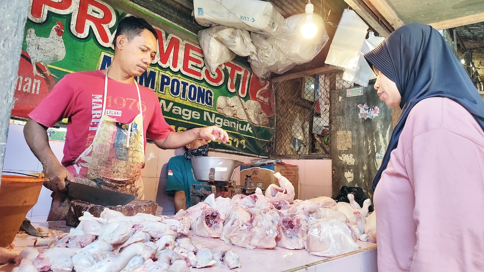 HARGA NAIK: Pedagang ayam di Pasar Wage Nganjuk melayani pembeli. Harga ayam tembus Rp 32 ribu per kg.