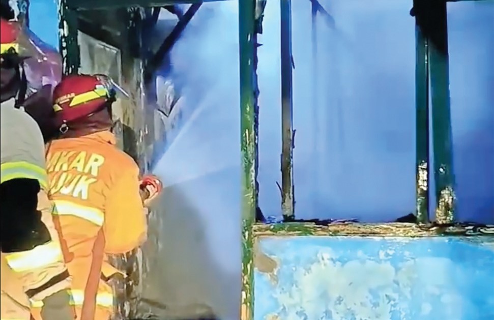 LUDES TERBAKAR: Petugas Damkarmat Nganjuk memadamkan ai yang melalap rumah warga desa Banjarejo, Rejoso.