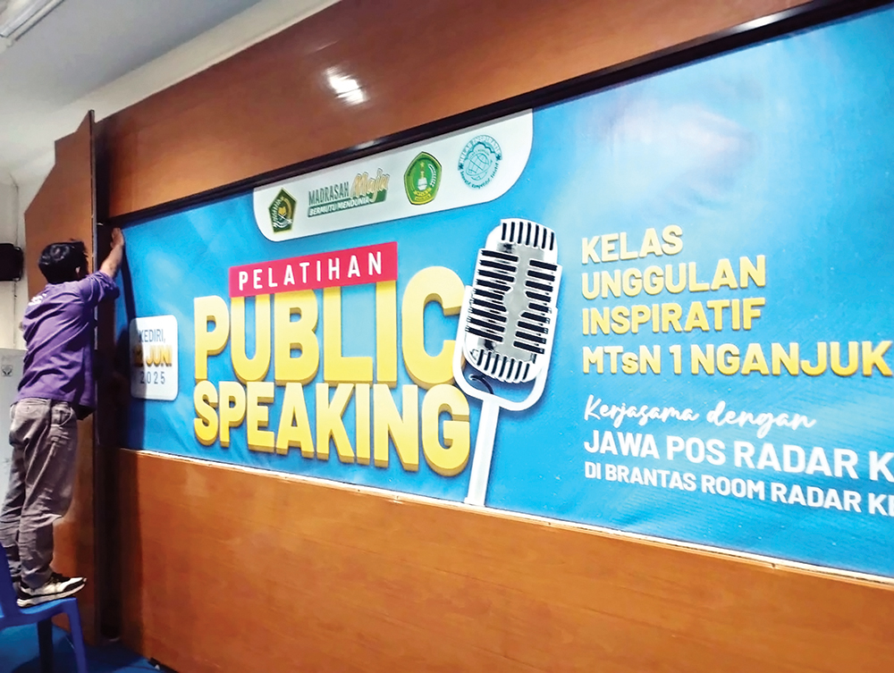 PERSIAPAN: Panitia memasang banner untuk Studi Lapangan dan Literasi di Brantas Room Jawa Pos Radar Kediri kemarin.