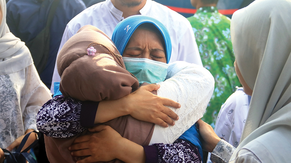 MENGHARUKAN: Jemaah Haji Kabupaten Nganjuk memeluk keluarganya setelah tiba di Pendapa KRT Sosrokoesoemo pada Sabtu (14/6). Dua jemaah haji harus menjalani perawatan karena kondisinya sakit saat pulan