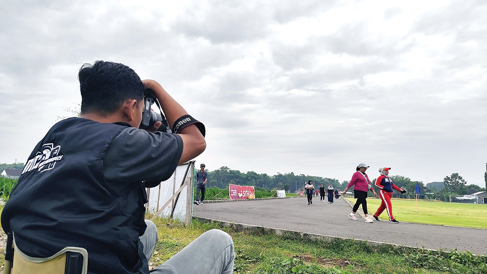 BIDIK OBJEK: Fotografer Sport Gilang Ramadan memotret warga yang joging. Setiap pagi dia mangkal di Lapangan Batembat, Pace.