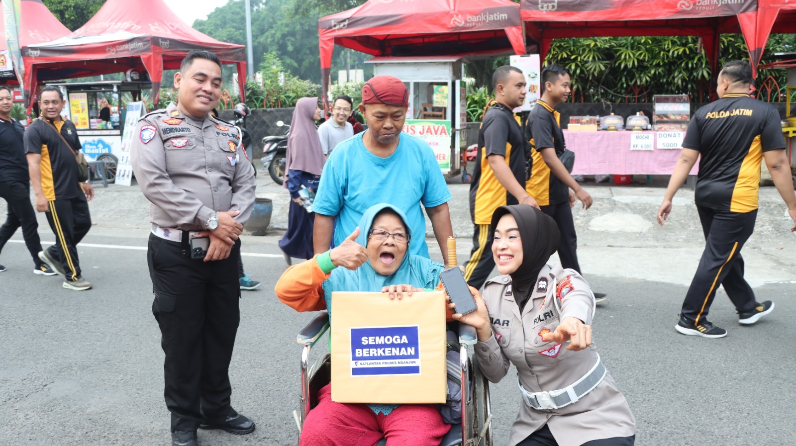 GEMBIRA, Warga mendapat doorprise dari Polres Nganjuk saat bakti sosial Hari Bhayangkara  di area CFD