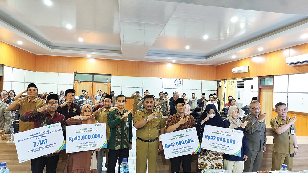 NGANJUK MELESAT: Bupati Marhaen Djumadi dan Kepala Disnaker Samsul Huda foto bersama setelah penyerahan anggota BPJS ketenagakerjaan pada pekerja sosial keagamaan di Ruang Roro Kuning Pemkab Nganjuk.