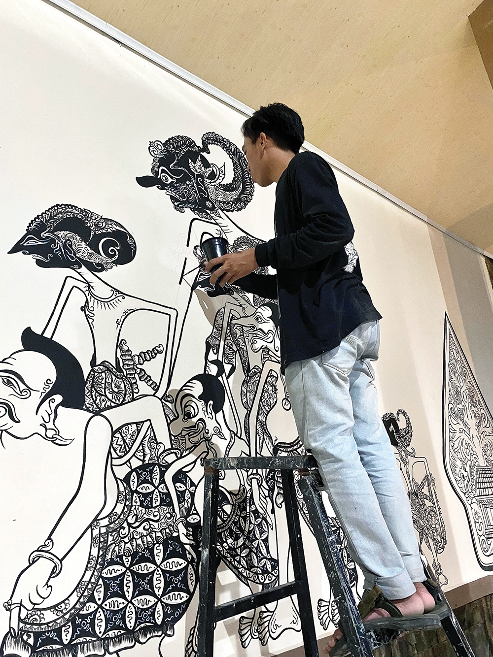 Brian saat mendapat orderan membuat mural wayang di tembok