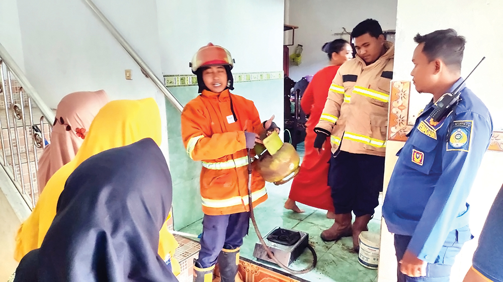 GEMPAR: Petugas Damkarmat Nganjuk melepas selang LPG yang bocor di rumah Sulismiati, warga Desa Betet, Kecamatan Ngronggot.