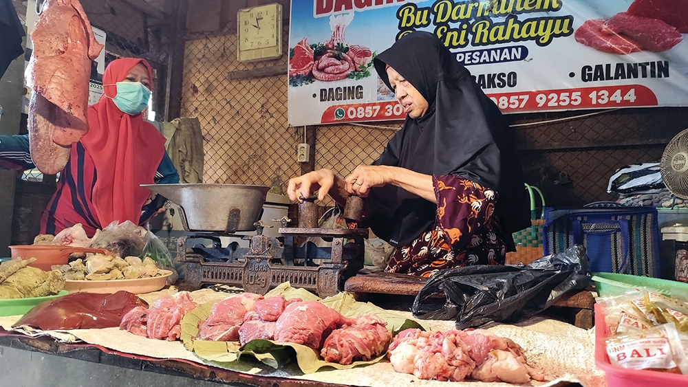 SEPI PEMBELI: Darminem, penjual daging di Pasar Wage Nganjuk melayani pembeli kemarin. Dua hari dia hanya mampu menjual lima kilogram daging.
