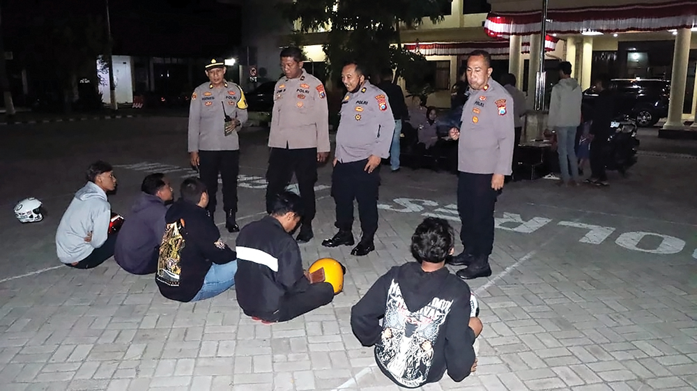 TINDAK TEGAS: Petugas Polres Nganjuk mengamankan belasan remaja yang konvoi motor saat sah-sahan PSHT. 18 motor disita.