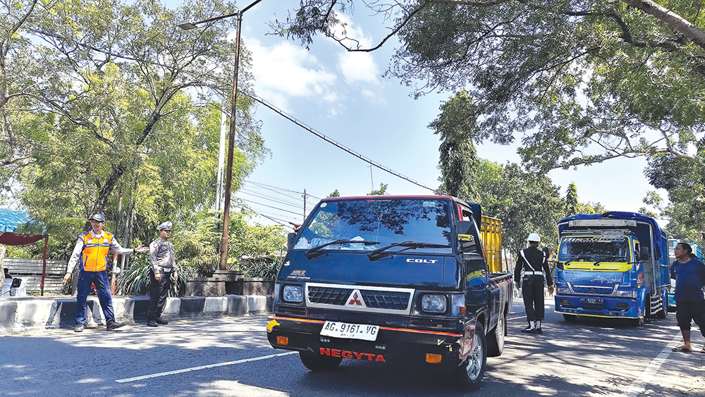 RAZIA GABUNGAN: Petugas memeriksa kendaraan yang mengangkut barang di Jalan Bengawan Solo kemarin. Sebanyak 27 kendaraan ODOL ditilang karena tidak uji KIR.