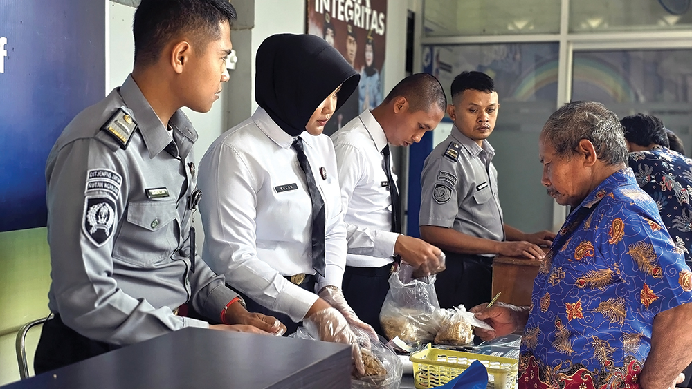 CEK MAKANAN: Petugas Rutan Kelas IIB Nganjuk mencicipi makanan yang diantar pembesuk pada warga binaan. Perkedel isi 100 butir pil dobel L bikin petugas rutan masuk RS.