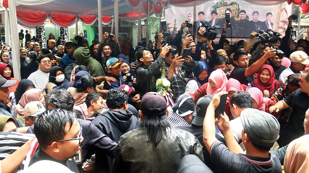 MERIAH: Pengunjung di Air Terjun Sedudo berebut gunungan. Disporabudpar sukses gelar acara Siraman.