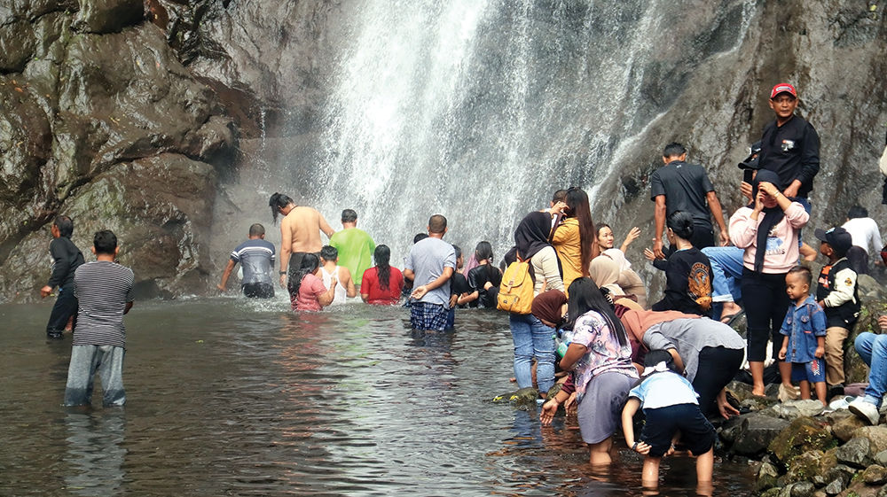 Ratusan pengunjung mandi di bawah Air Terjun Sedudo, Desa Ngliman, Kecamatan Sawahan. Mandi di sana saat Bulan Sura dipercaya bisa awet muda