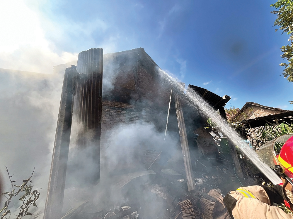 SEMPROT: Petugas Damkarmat Nganjuk padamkan api yang melalap dapur rumah warga Desa Senjayan, Kecamatan Gondang kemarin.