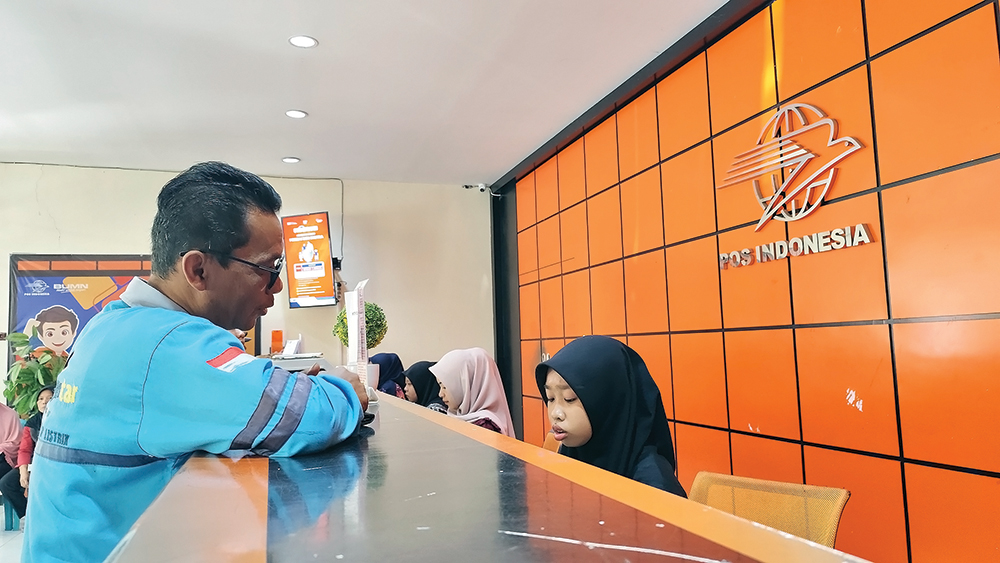 CAIRKAN BSU: Karyawan Kantor Pos Nganjuk melayani pencairan BSU.