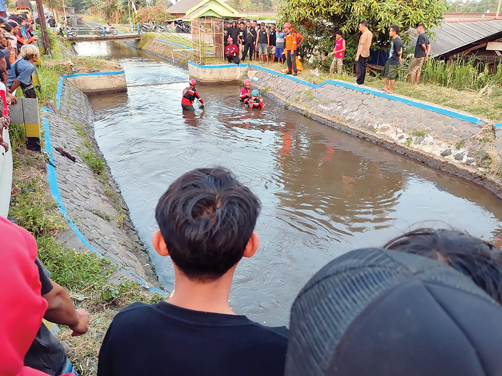 MENGENASKAN: Petugas BPBD Nganjuk mengevakuasi jenazah Komarudin, lansia yang tertabrak kereta api hingga terpental ke Kalimati kemarin.