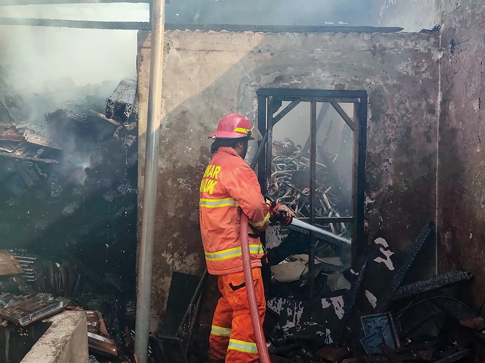 KERJA KERAS: Petugas Damkarmat memadamkan si jago merah yang melalap rumah Abdul Rochim, warga Bagor.