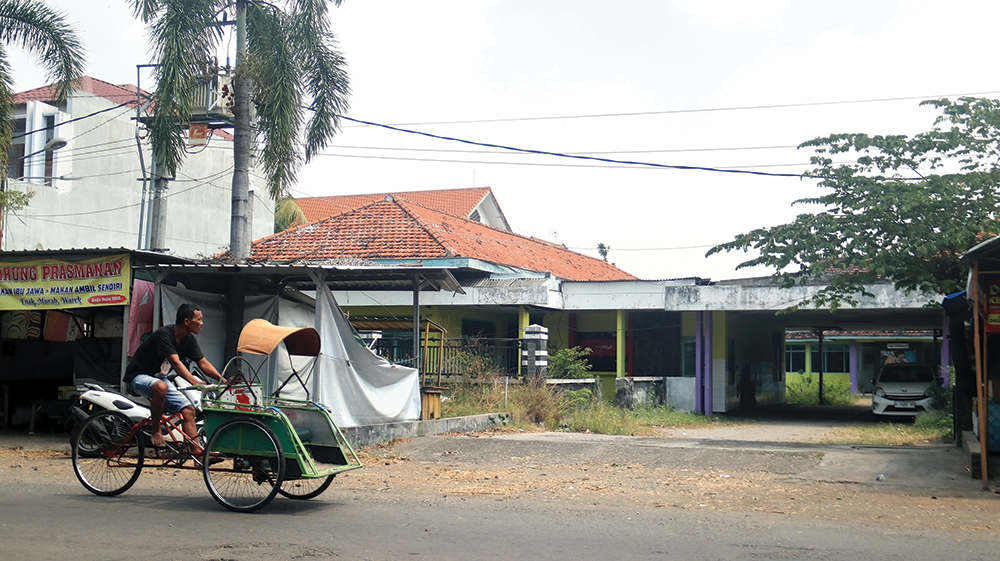MANGKRAK: Tukang becak melintas di depan bangunan Rumah Sakit Umum Daerah (RSUD) Kertosono lama yang tidak terpakai karena RSUD pindah ke Desa Kepuh. RSU
