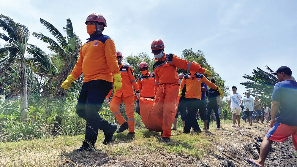BIKIN GEMPAR: Petugas BPBD Nganjuk mengevakuasi jenazah Zaini yang tewas tercebur sumur kemarin.