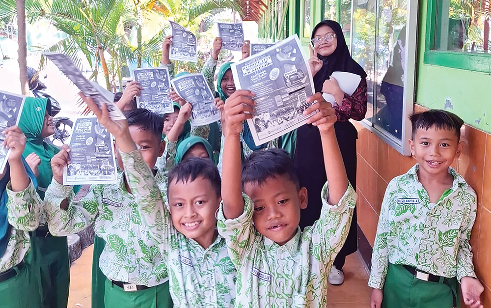 ANTUSIAS: Siswa SDN 1 Kauman menunjukkan brosur Kompetisi Kompetensi Akademik Jawa Pos Radar Kediri.