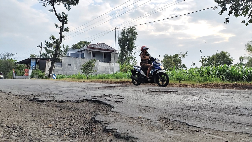 MENGENASKAN: Aspal di Jalan Desa Godean, Kecamatan Loceret mengelupas kemarin. Dinas PUPR Nganjuk akan memperbaiki tahun ini.