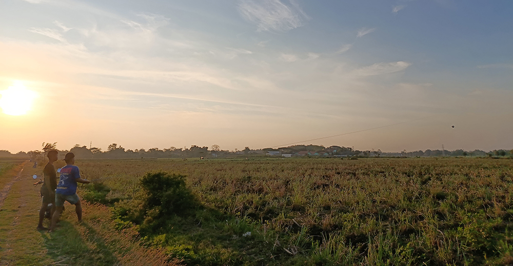 PUNCAK KEMARAU: Warga di Desa Sanan, Kecamatan Pace bermain layang-layang di sawah. Musim kemarau di Kabupaten Nganjuk diprediksi puncaknya akhir bulan ini.