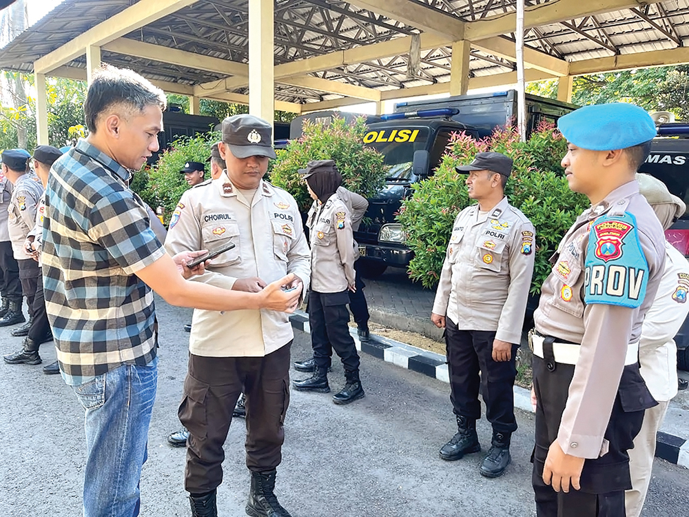 CEGAH PERJUDIAN: Anggota Propam Polres Nganjuk mengecek handphone anggota polres untuk mencegah terlibat judol.