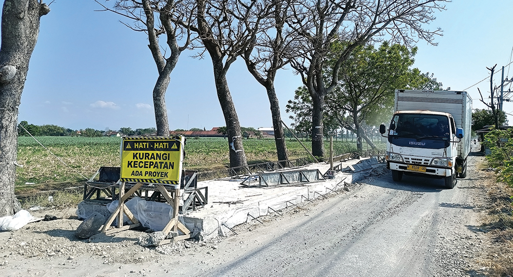 BARU SEPARO: Truk melintas di Jalan Sukomoro-Kecubung yang belum selesai perbaikannya. Pembangunan jalan berhenti selama 28 hari karena menunggu cor kering.