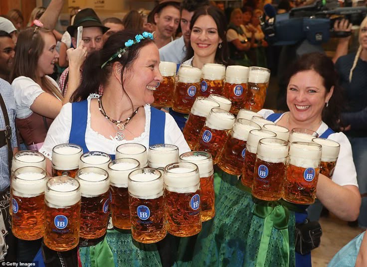 Suasana Oktoberfest di M&uuml;nchen, Jerman, pelayan perempuan membawa gelas-gelas bir jumbo.
