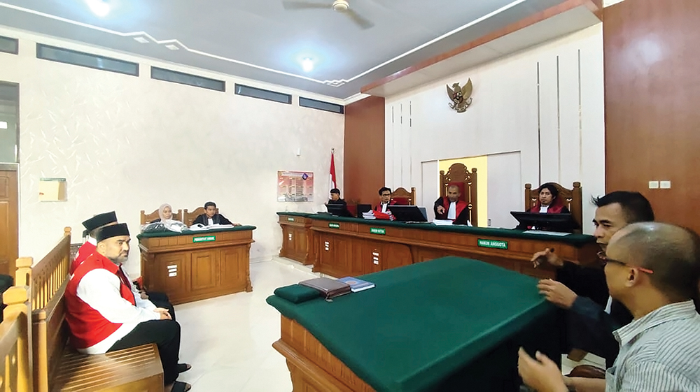 BINGUNG: Bapak dan anak warga Iran mendengarkan penjelasan dari penerjemah saat sidang.