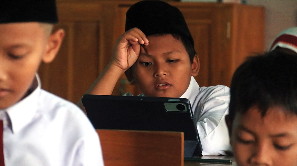 MEMERAS OTAK: Salah satu siswa MIN 2 Nganjuk berpikir keras mengerjakan soal matematika di babak penyisihan Kompetisi Kompetensi Akademik tingkat SD/MI.