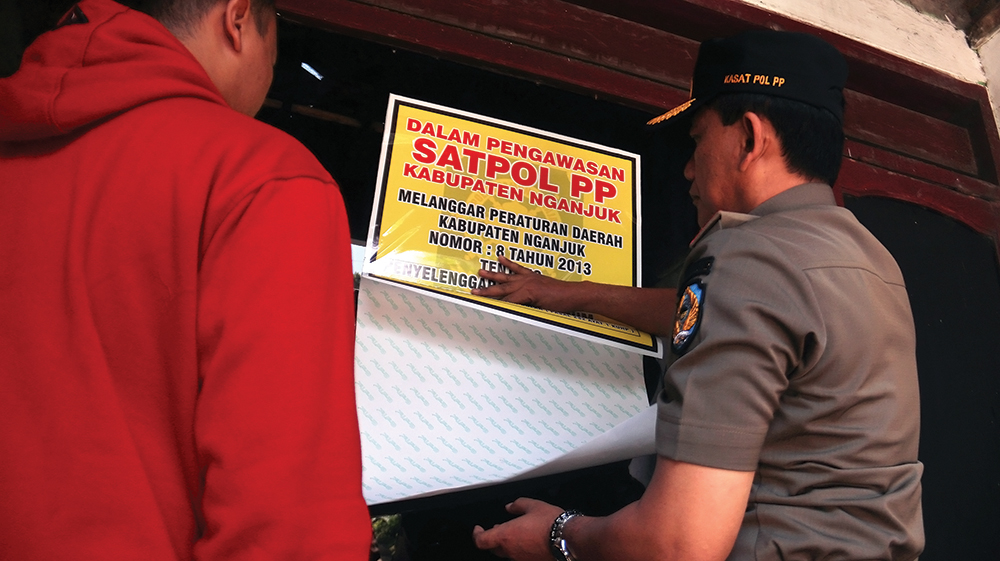 MELANGGAR PERDA: Petugas Satpol PP menyegel rumah kos jam-jaman di Nganjuk yang dijadikan tempat mesum kemarin.