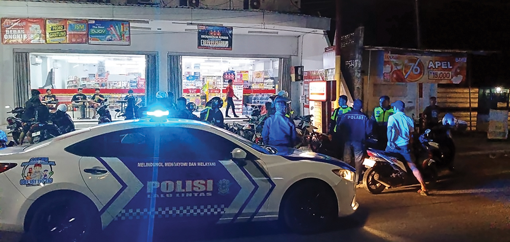 PATROLI MALAM HARI: Petugas Polres Nganjuk membubarkan pemuda yang nongkrong saat malam hari di tepi jalan raya.