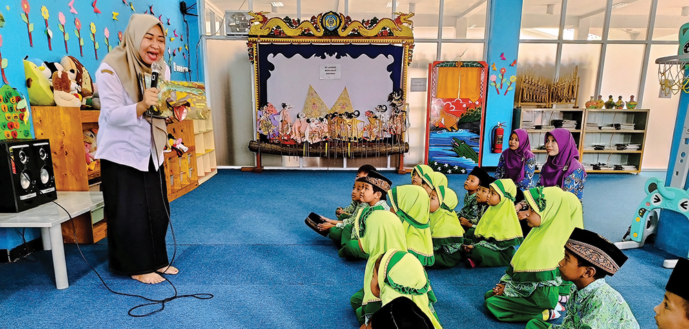 MENGHIBUR: Lina Hermita, pegawai perpusda mendongeng saat anak TK berkunjung.
