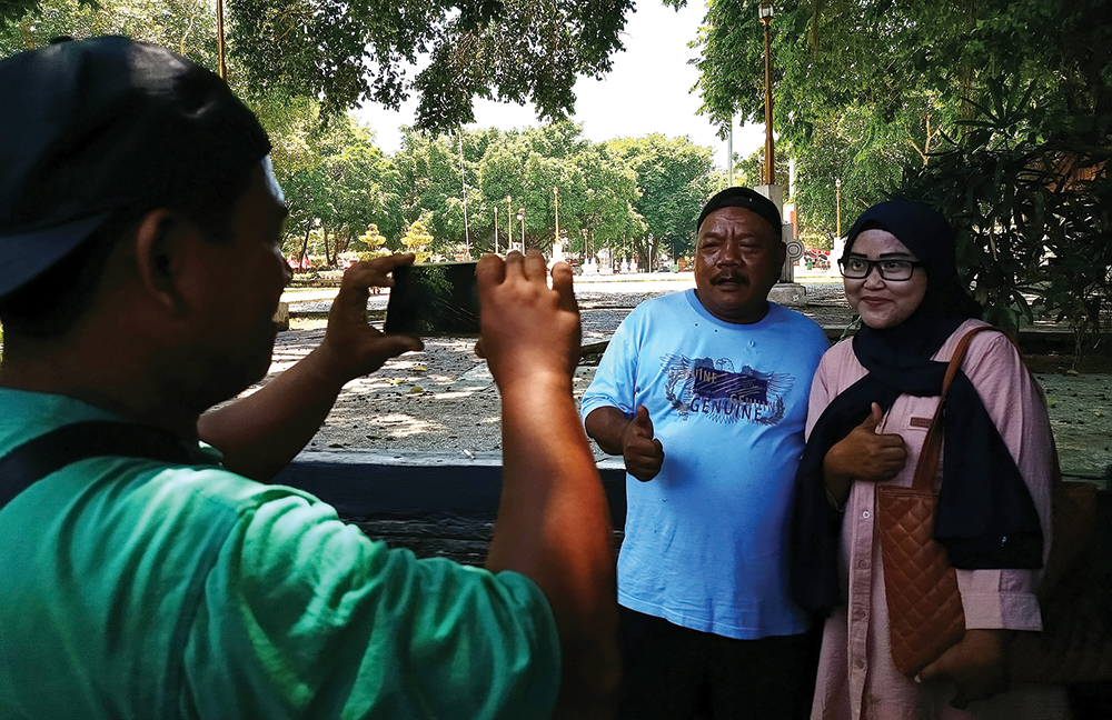 MENARIK PERHATIAN : Pak Ndut, salah satu pemain Woko Channel diajak foto warga di Alun-Alun Nganjuk kemarin (22/8).