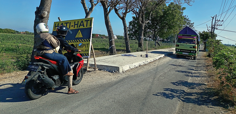 HARUS BERGANTIAN: Pengendara sepeda motor menunggu truk yang akan melintas di Jalan Sukomoro-Kecubung. Perbaikan jalan tersebut kembali dilakukan.