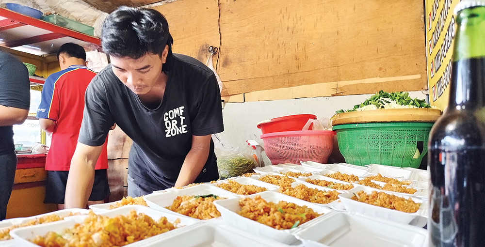 LARIS: Karyawan di warung milik Priyo menyiapkan pesanan nasi goreng yang akan dibagikan ke warga sekitar.