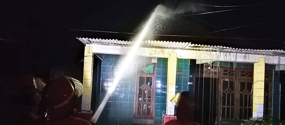 TERBAKAR: Petugas Damkarmat Nganjuk menyemprotkan air untuk memadamkan api yang melalap rumah warga Sukomoro.