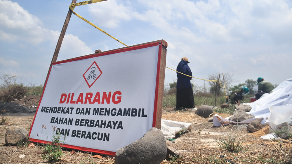 BERBAHAYA: Petugas Dinas Lingkungan Hidup (DLH) Kabupaten Nganjuk mengambil sampel limbah beracun yang dibuang di Desa Putren, Kecamatan Sukomoro kemarin. Warga dilarang mendekat.