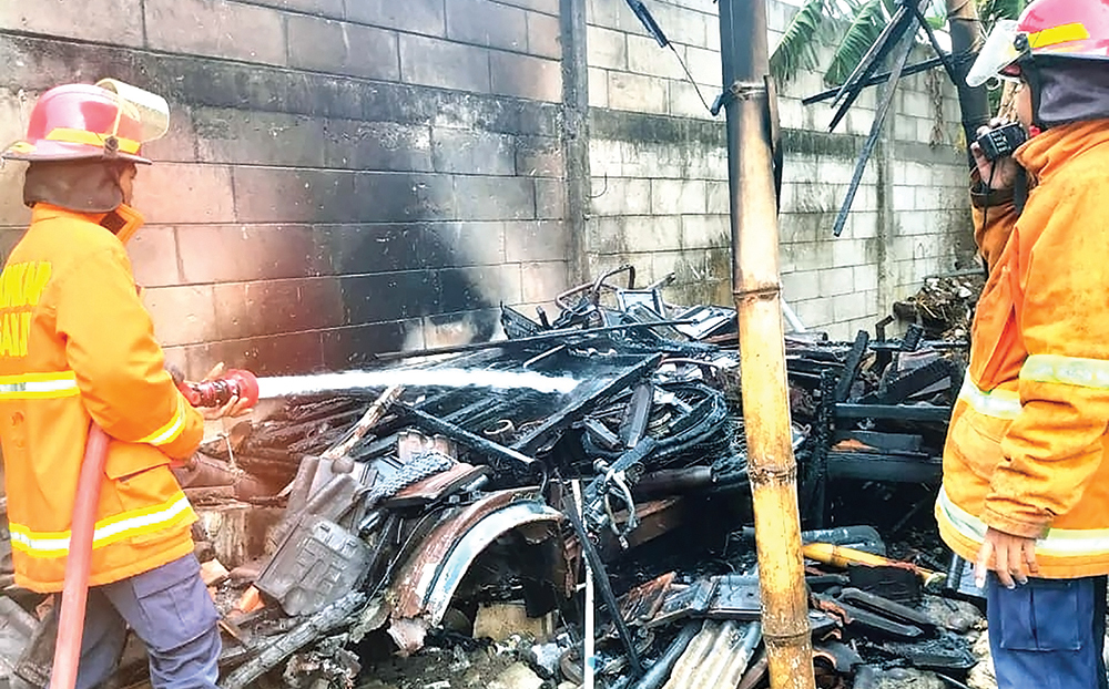 PADAMKAN API: Petugas Damkarmat Nganjuk menyemprot si jago merah yang melalap gudang SMK di Prambon.