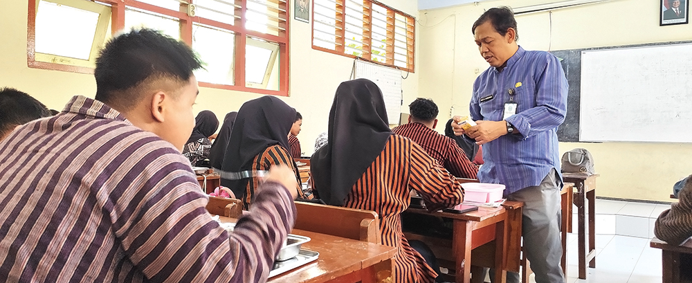 Guru sedang menemani siswa makan bersama menu MBG.