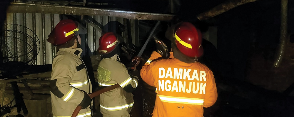 KORSELTING LISTRIK: Petugas Damkarmat Nganjuk memadamkan api yang melalap dapur rumah warga Desa Bungur, Sukomoro.