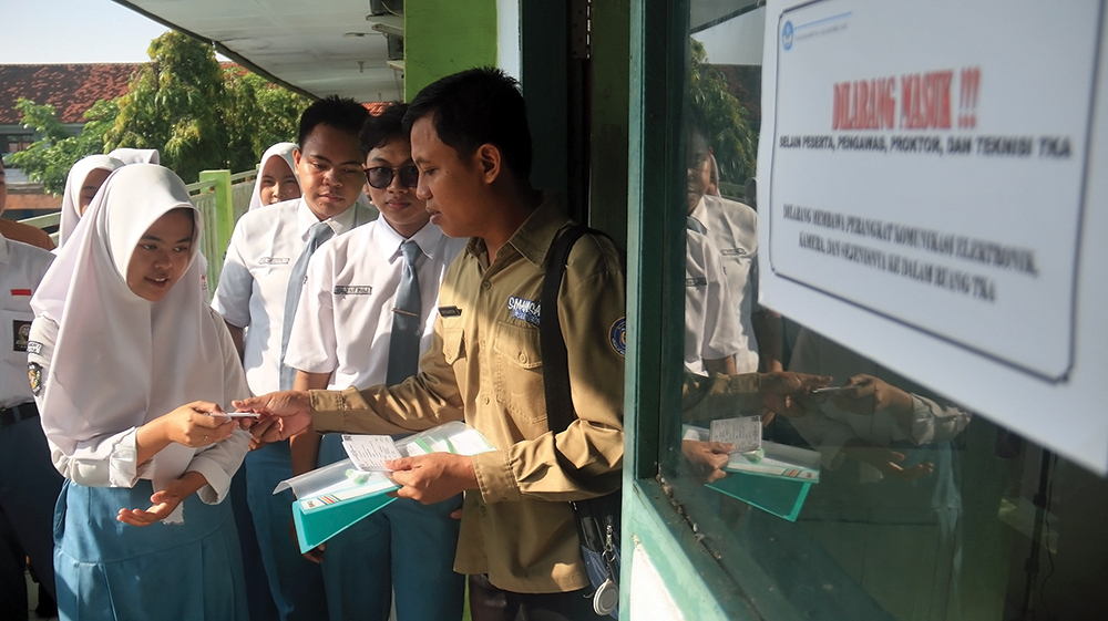 PENGAWASAN KETAT: Pengawas mengecek kartu peserta TKA di SMAN 1 Nganjuk untuk cegah kecurangan.