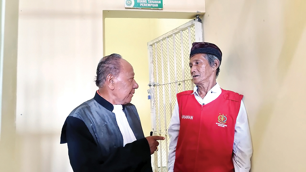 BAJU PINJAMAN: Atmorejo Sagi berdiskusi dengan pengacaranya. Dia tak punya baju putih.